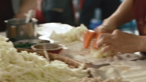 Close up view of baker's hand adding diced cabbage into wrapper Stock Footage 103401933