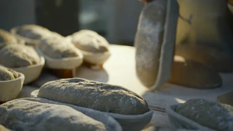 Close view of baker's hands throw out freshly roasted bread from organic dishes Vídeo Stock 147254167