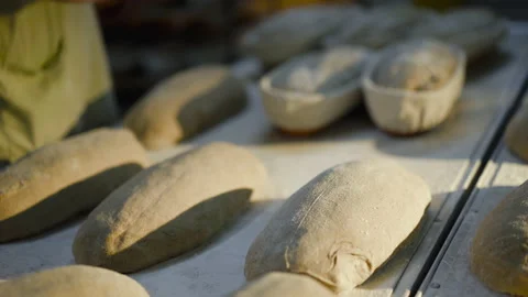 Close view of baker's hands throw out freshly roasted bread from baking dishes Stock Footage 147254229