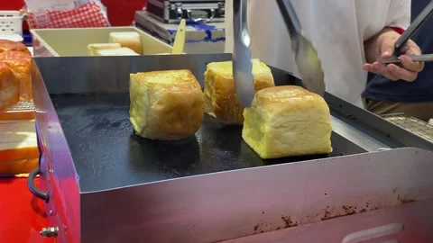 Close up view baking bread on hot pan at retail stall at night market. Video stock 262464874