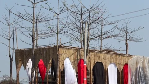 Close view of bamboo structure with hanging red, white, and black fabric Stock Footage 331277059