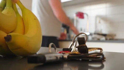 Close up view of bananas and a man washing dishes in the blurred background Stock Footage 148045973
