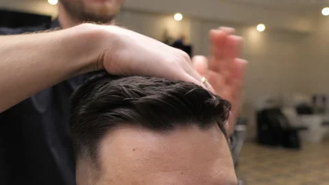 Close up view of barber making hairstyle to the client. Men's hairdo. Video stock 149703408