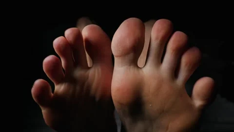 Close Up View of Bare Feet and Toes Flexing in Dramatic Low Key Lighting Видео 339366282