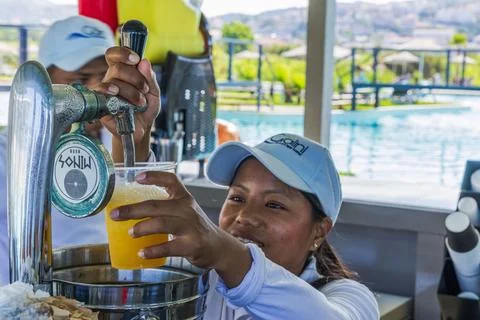 Close-up view of bartender pouring Mythos beer from tap into plastic cup Stock Photos