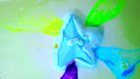 Close-up view like a bath bomb dissolves with foam of various colors Stock Footage 185725774