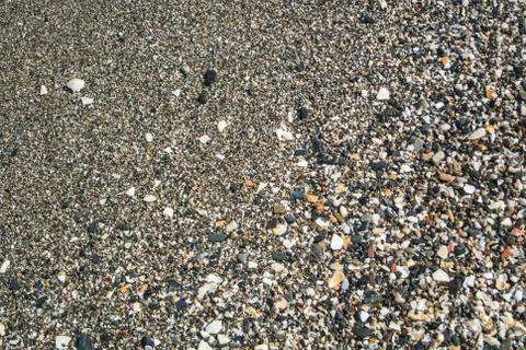 Close up view of beach with small stones, sand and shells at Malaga, Andalu.. Stock Photos
