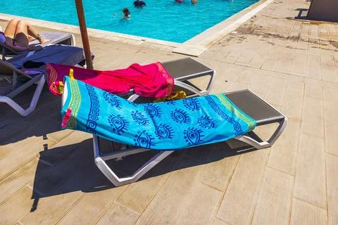 Close up view of  beach towels on sun loungers near swimming pool with people Foto stock