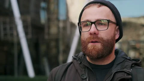Close up view of bearded man looking gloomy and worried while walking at street Video stock 139937246