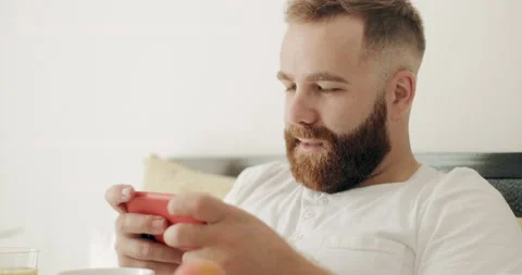 Close up view of bearded man playing game on modern mobile phone and looking Stock Footage 131096992