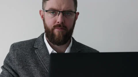 Close up view of bearded middle aged man in glasses using laptop computer Stock Footage 180398068