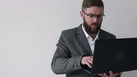 Close up view of bearded middle aged man in glasses using laptop computer Stock Footage 180398099
