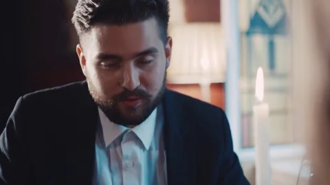 Close up view of a bearded young guy talking, and eating something in restaurant Stock Footage 74624370