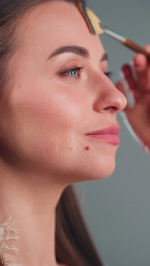 Close-up view of beautician applying powder blush with professional fan bru.. Stock Footage 332660880