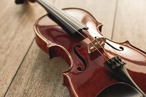 Close up view of beautiful classical violin lying on wooden background. Music Stock Photos