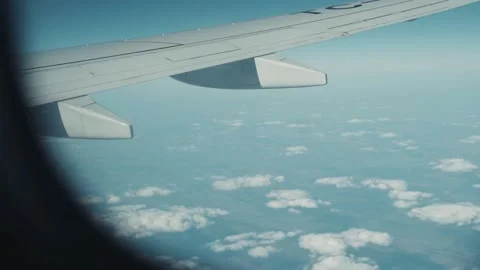 Close up view of beautiful cloud and wing of airplane from window with blue sky Stock Footage 138706042