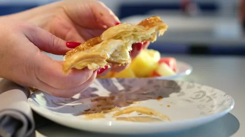 Close-up view of a beautiful female hands tearing fresh croissant. Woman Hand Stock Footage 322585575