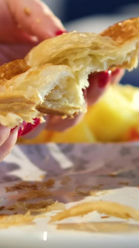 Close-up view of a beautiful female hands tearing fresh croissant. Woman Hand Stock Footage 323931128