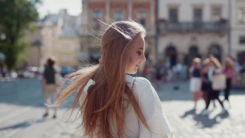 Close up view of beautiful young blue-eyed woman in white blouse turning to Stock Footage 112673178