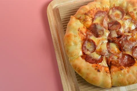 Close up view of Beef Pepperoni cheesy pizza isolated on pink background Stock Photos