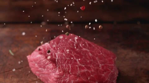 Close view of beef slices sprinkled with seasonings. Stock Footage 231249439