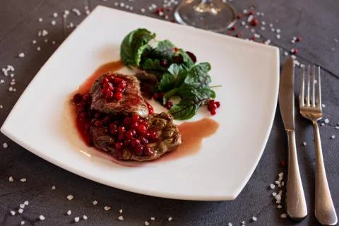 Close up view of the beef steak covered with lingonberry dressing and beet le Stock Photos
