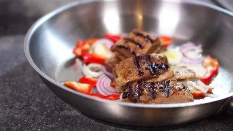 Close up view on beef steak meat fried on frying pan with fresh vegetables Stock Footage 105457526