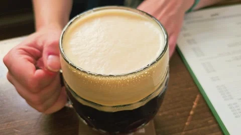 Close view of a beer mug being picked up in a bar, with creamy foam, dark Stock Footage 339235971