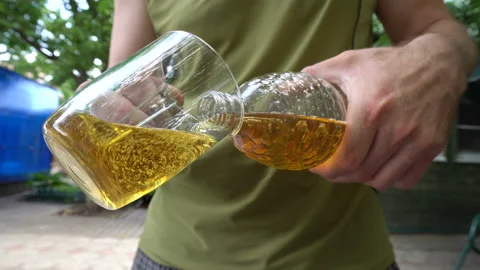Close-up view of a beer pouring from a plastic bottle into a glass mug 4K Stock-Footage 115861568