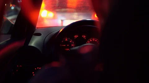 Close-up view behind a driver in a car, the car don't move at a night road 動画素材 126995157