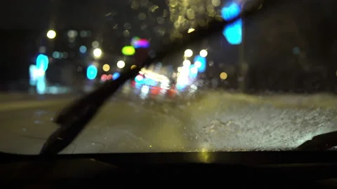 Close-up view from behind the wheel of a car, water splashes on the windshield Stock Footage 146411594