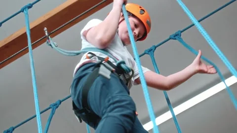 Close-up view from below. A brave boy in an extreme rope park. Stock Footage 275326123