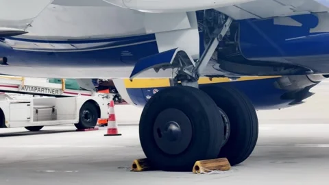 Close-up view beneath a parked jet showing the engine, landing gear, wheel Stock Footage 338003413