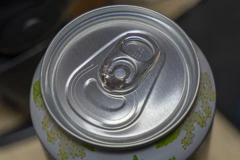 Close-up view of a beverage can top featuring a pull tab mechanism. The Stock Photos