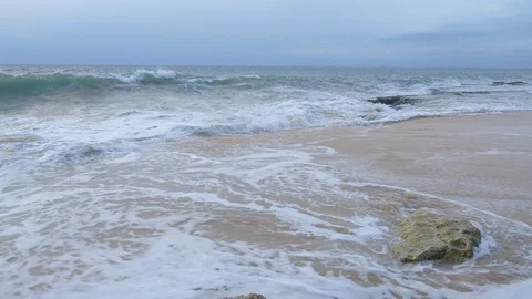 Close up view of a big waves are hitting rocky beach with sand and stones Stock Footage 114989617