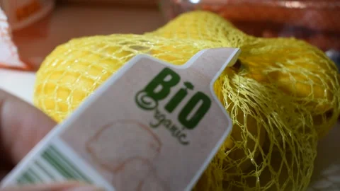 Close-Up View of Bio Organic Label on Yellow Mesh Produce Bag Stock Footage 325874826