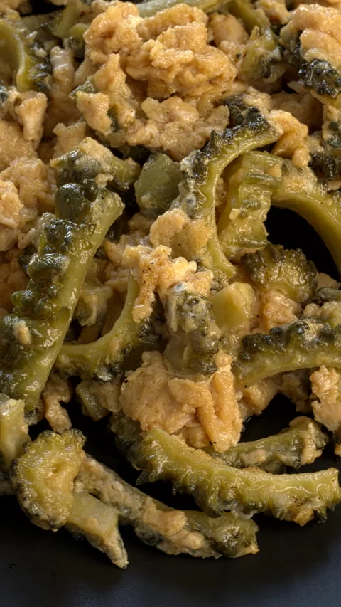 Close-up view of bitter melon stir-fry with eggs. Vertical video. Stock Footage 284557484