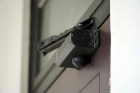 Close up view of a black automatic hydraulic door closer hardware installed  Stock Photos