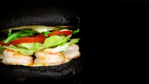 Close up view of Black burger with shrimps, copy space on right side, loop Stock Footage 75253615