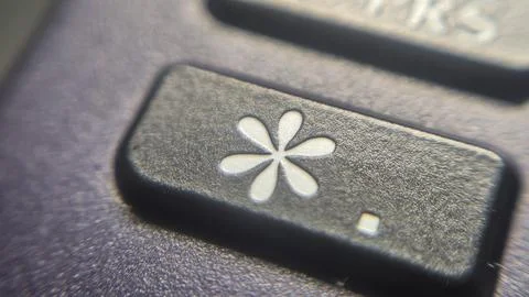Close-up view of a black button with a flower-like symbol, representing various Stock Photos