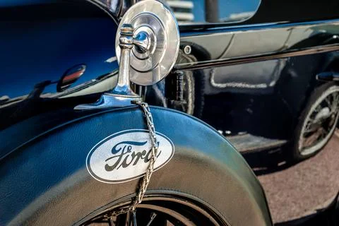 Close view of black Ford Model T spare wheel in leather case and rear mirror Stock Photos
