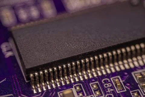 Close-up view of a black integrated circuit chip mounted on a purple printe.. Stock Photos