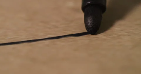 Close-up view of black marker creating a smooth line on textured paper surface, Stock Footage 317557086