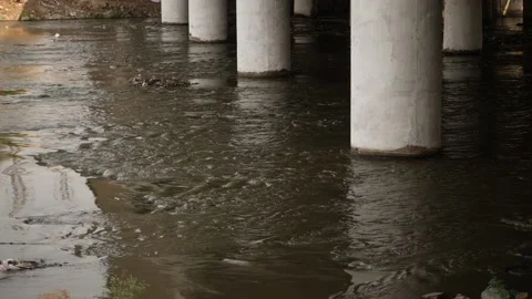 Close view of black water flowing under bridge, Industrial water flowing Stock Footage 148535973