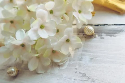 Close up view of blooming white hydrangea with golden beads on wooden backgro Stock Photos