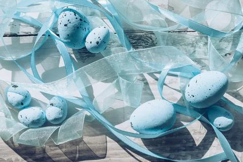 Close up view of blue spotted eggs and blue organza and atlas ribbons Stock Photos