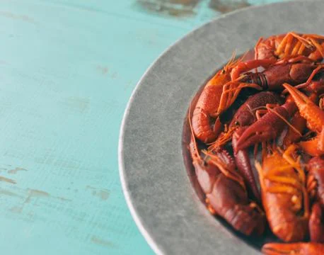 Close up view of boiled crawfish on a rustic platter and vintage table. Fotos de archivo