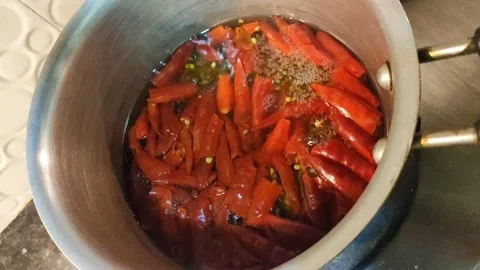 Close view of boiling dry red chilies in a saucepan Stock Footage 152386725
