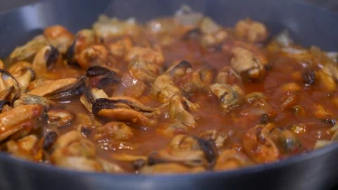 Close view of boiling tomato sauce with mussels, hot bubbles rising on surface Stock Footage 321818328