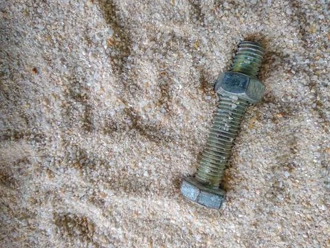 Close-up view of bolt and nut on the sand Stock-Fotos